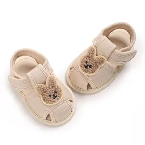 Vue détaillée de chaussures de marche bébé beige avec semelle souple et décor lapin.