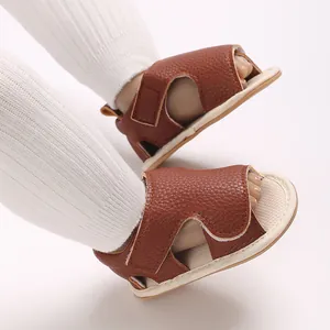 Detail shot of brown leather baby sandals with soft soles for pre-walking babies.