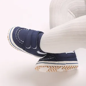 Vue rapprochée de chaussures de marche bébé bleu marine avec semelles antidérapantes.