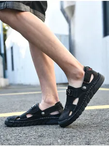 Vue détaillée des sandales d'été en cuir noir cousues main pour hommes à la plage.