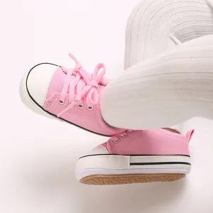 Detailed view of pink canvas infant sneakers featuring soft non-slip rubber soles