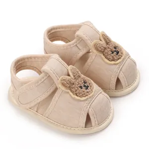 Gros plan de chaussures de marche pour bébé beiges avec patch lapin et semelle souple