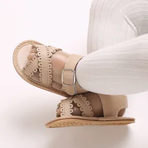 Detail van baby sandalen voor meisjes met beige geschulpte bandjes en gespsluiting