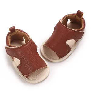 Detailweergave van bruine baby sandalen van kunstleer met zachte zolen en klittenband.