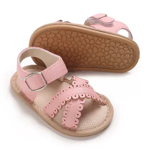 Detailweergave van roze babysandalen voor meisjes met opengewerkte patronen en zolen.