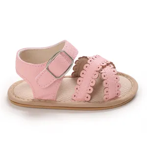 Detailopname van roze baby sandalen met geschulpte bandjes en een mooie zilveren gesp