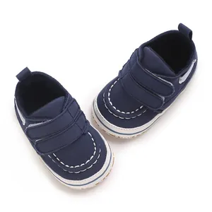 Détail de chaussures de marche pour bébé en toile bleu marine avec brides velcro