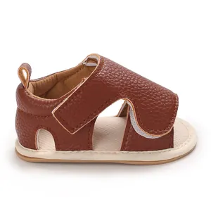 Macro view of brown faux leather baby sandal with soft sole and pebble texture detail