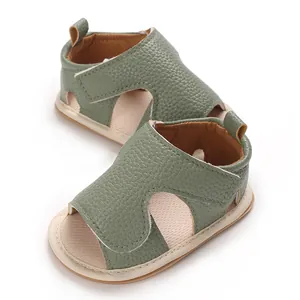 Close-up van groene baby wandel sandalen met zachte zolen en klittenband voor de zomerperiode.
