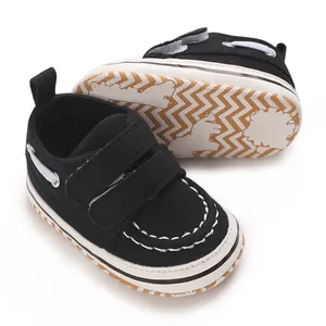 Vue détaillée de chaussures de marche pour bébé noires avec velcro et semelle antidérapante.