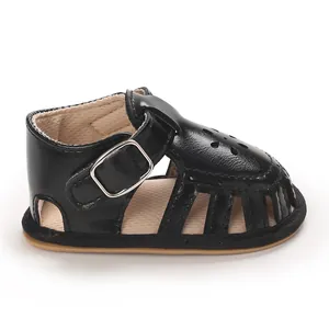 Close-up of black baby girl pre-walker sandal with flower cutouts and buckle strap