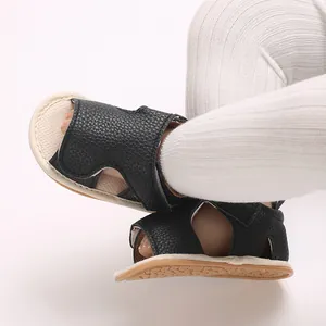 Close-up of black leather baby sandals with soft non-slip soles for toddlers and infants