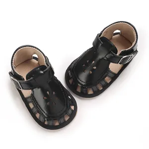 Close-up of stylish black baby sandals with soft soles and decorative flower cut-outs