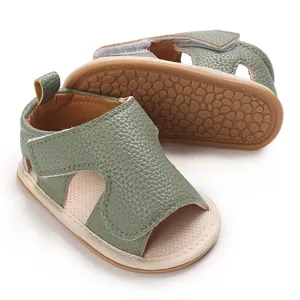 Detailed view of green textured leather baby walking sandals with soft rubber soles.