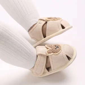 Gros plan détaillé de chaussures pour bébés beiges avec semelles souples et motifs