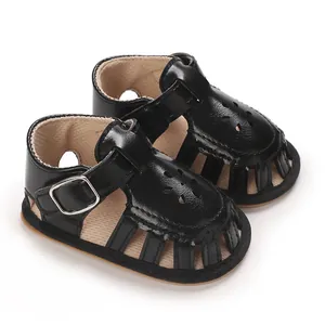 Close-up of black baby girl sandals with soft sole and buckle strap design