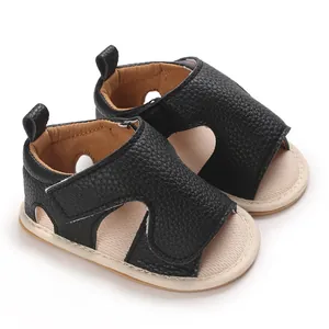 Detailed view of black pebbled leather baby sandals featuring soft soles and hook-and-loop straps