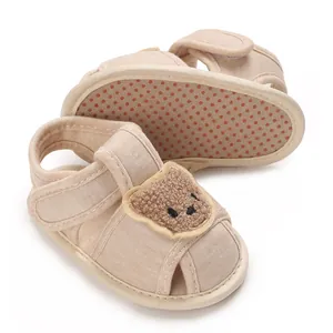 Vue détaillée de chaussures bébé beiges avec motif ours en peluche et semelle souple antidérapante