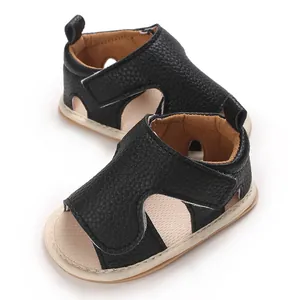 Gedetailleerd overzicht van zwarte baby sandalen van generfd leer met zachte beige zolen