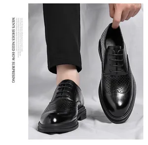 Close-up detail of black leather brogue shoes with intricate perforation patterns