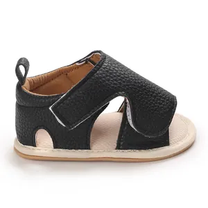 Detail of black pebbled leather baby sandal with soft beige sole and velcro strap