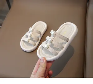 Vista detallada de las elegantes zapatillas beige para niña con adornos de perlas