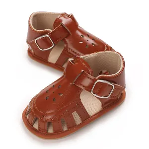 Detail view of brown baby girl sandals with laser-cut flower design and soft sole.