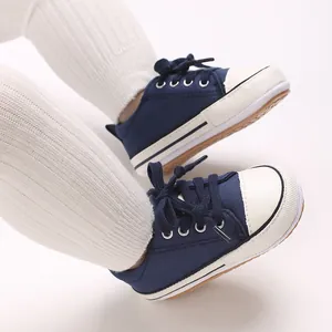Close-up of navy baby canvas sneakers with soft soles for pre-walking infants.