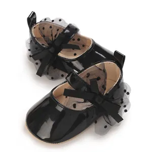 Nahaufnahme von schwarzen Lackleder-Babyschuhen mit gepunkteten Spitzenschleifen