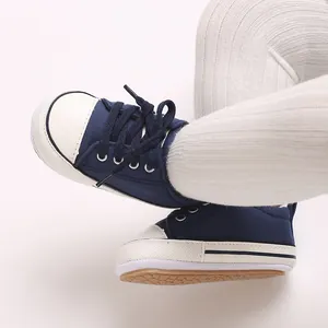 Macro view of navy blue canvas baby walking shoes with soft soles and white caps