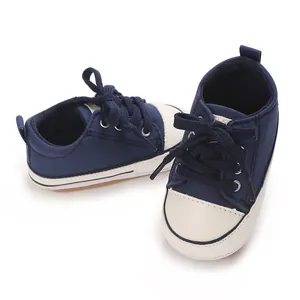 Close-up of navy blue baby canvas sneakers with soft white soles for infants