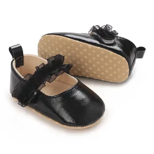 Gros plan de chaussures bébé vernies noires montrant la semelle antidérapante.