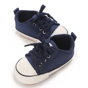 Detail shot of navy blue baby canvas pre-walker shoes with white soft soles and laces