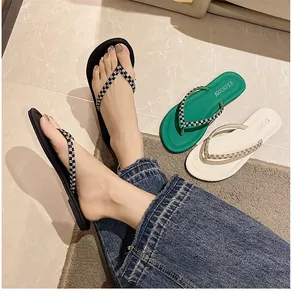 Tongs élégantes pour femmes avec brides tressées, sandales de plage plates en noir, vert et blanc.