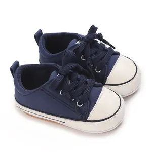 Detailed side view of navy blue baby canvas shoes with soft white soles and laces
