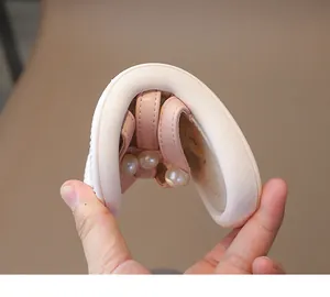 Vista detallada de la suela flexible y blanda de las sandalias rosas con perlas