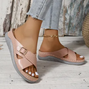 Elegant pink summer wedge sandals with buckle strap and perforated design on wooden floor