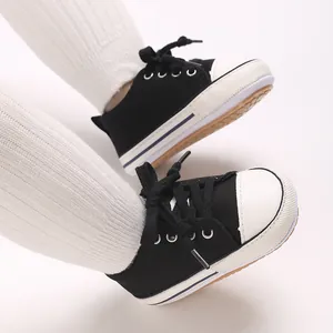 Close-up of black and white baby canvas sneakers with soft soles for pre-walkers and infants.