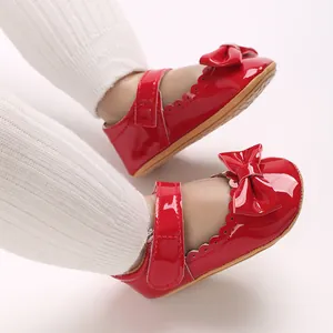 Vista detallada de zapatos rojos de charol para bebé con lazo y borde festoneado