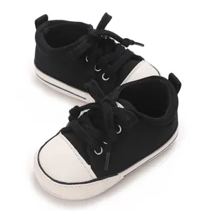 Detailed view of black and white baby canvas sneakers with soft soles for pre-walking.