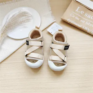 Close-up of beige mesh baby toddler sandals with Velcro straps and white soft soles