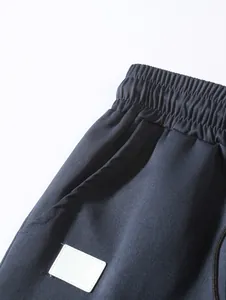 Close-up detail of navy blue men's woven shorts showing the elastic waistband and pocket