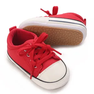 Detailed macro view of red infant canvas pre-walker shoes with soft anti-slip sole