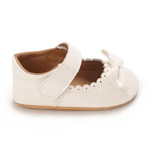 Vista lateral del zapato de princesa para bebé en charol blanco con un lazo suave
