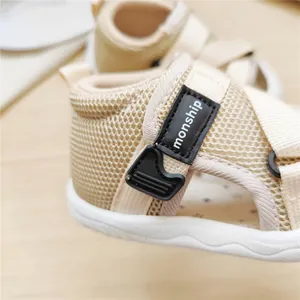 Close-up detail of breathable beige mesh baby sandals with monship velcro strap