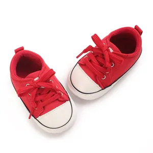 Top down view of red infant canvas walking shoes with white toes and soft soles