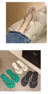 Gros plan de tongs plates pour femmes avec lanières tressées en strass