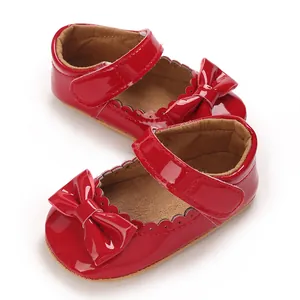 Zapatos de bebé de charol rojo con lazos y detalles de bordes festoneados suaves