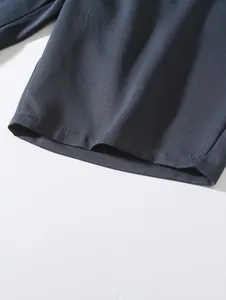 Macro view of navy blue woven fabric hem showing precise stitching on men's beach shorts