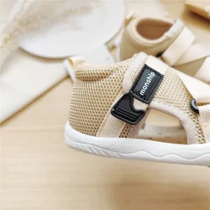 Close-up detail of breathable beige baby walking sandals with monship velcro strap